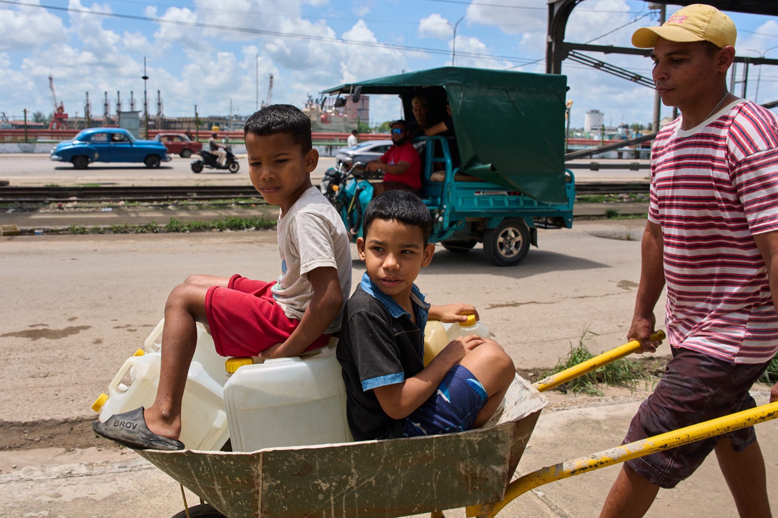 Un hombre transporta bidones de agua con sus hijos en La Habana, el jueves 28 de mayo de 2026 (Foto AP/Ram&oacute;n Espinosa)