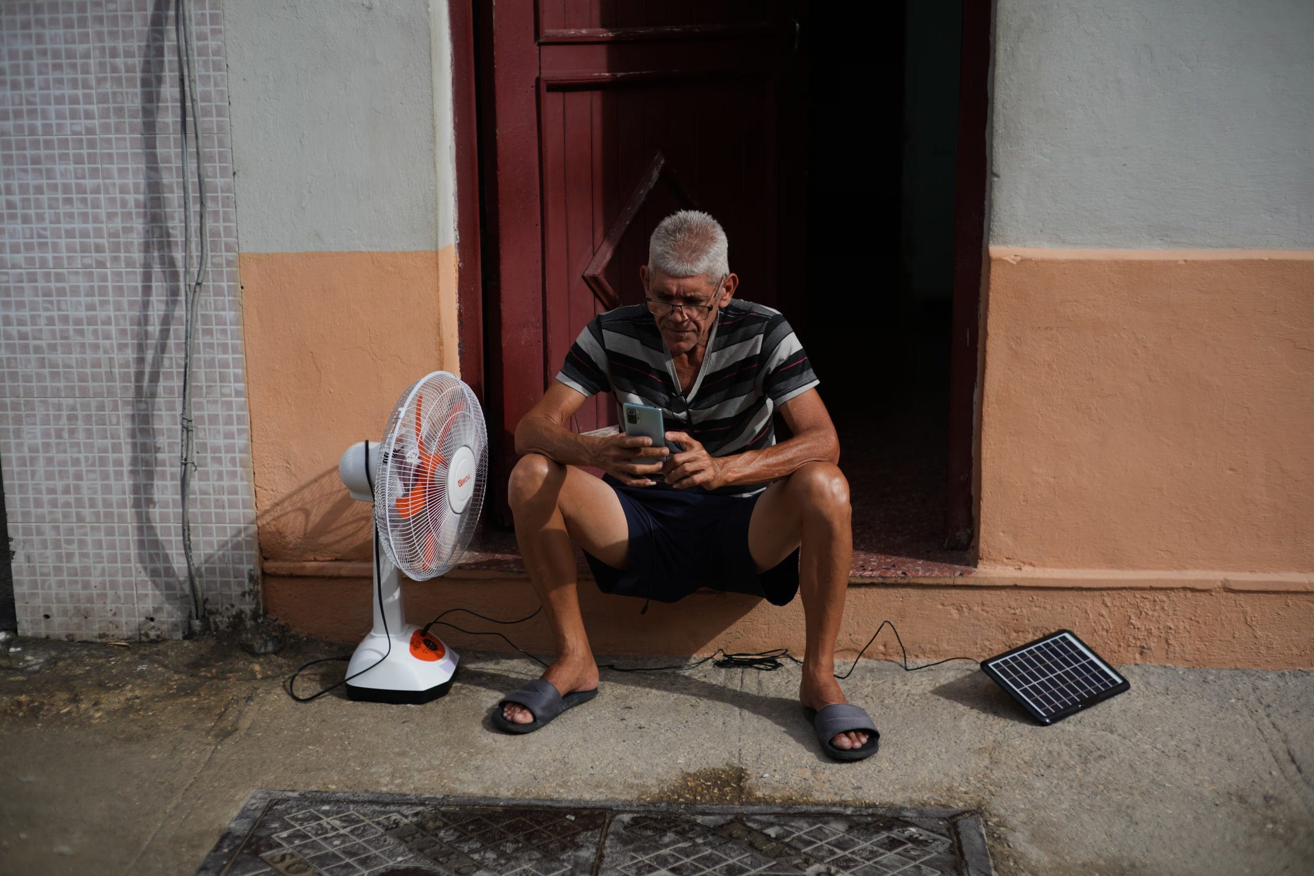 Un hombre carga su ventilador y su tel&eacute;fono celular con un panel solar durante un apag&oacute;n en La Habana, el 17 de marzo del 2026 (AP foto/Ram&oacute;n Espinosa)