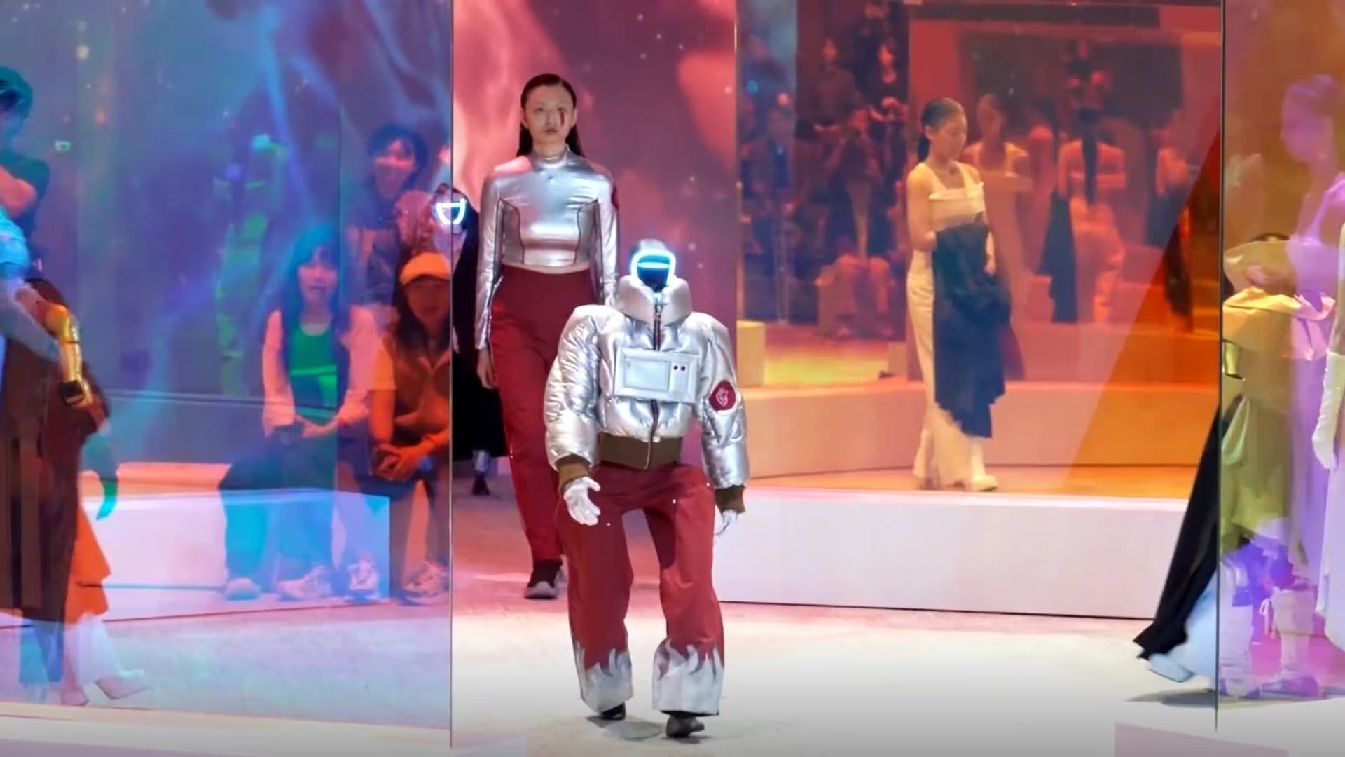 Organizado por Galaxy Corporation, el desfile presentó atuendos coordinados y rutinas coreografiadas para ilustrar un futuro de interacción cotidiana con robots, en una apuesta por normalizar su presencia fuera de fábricas, ferias y laboratorios - (Captura/Reuters)