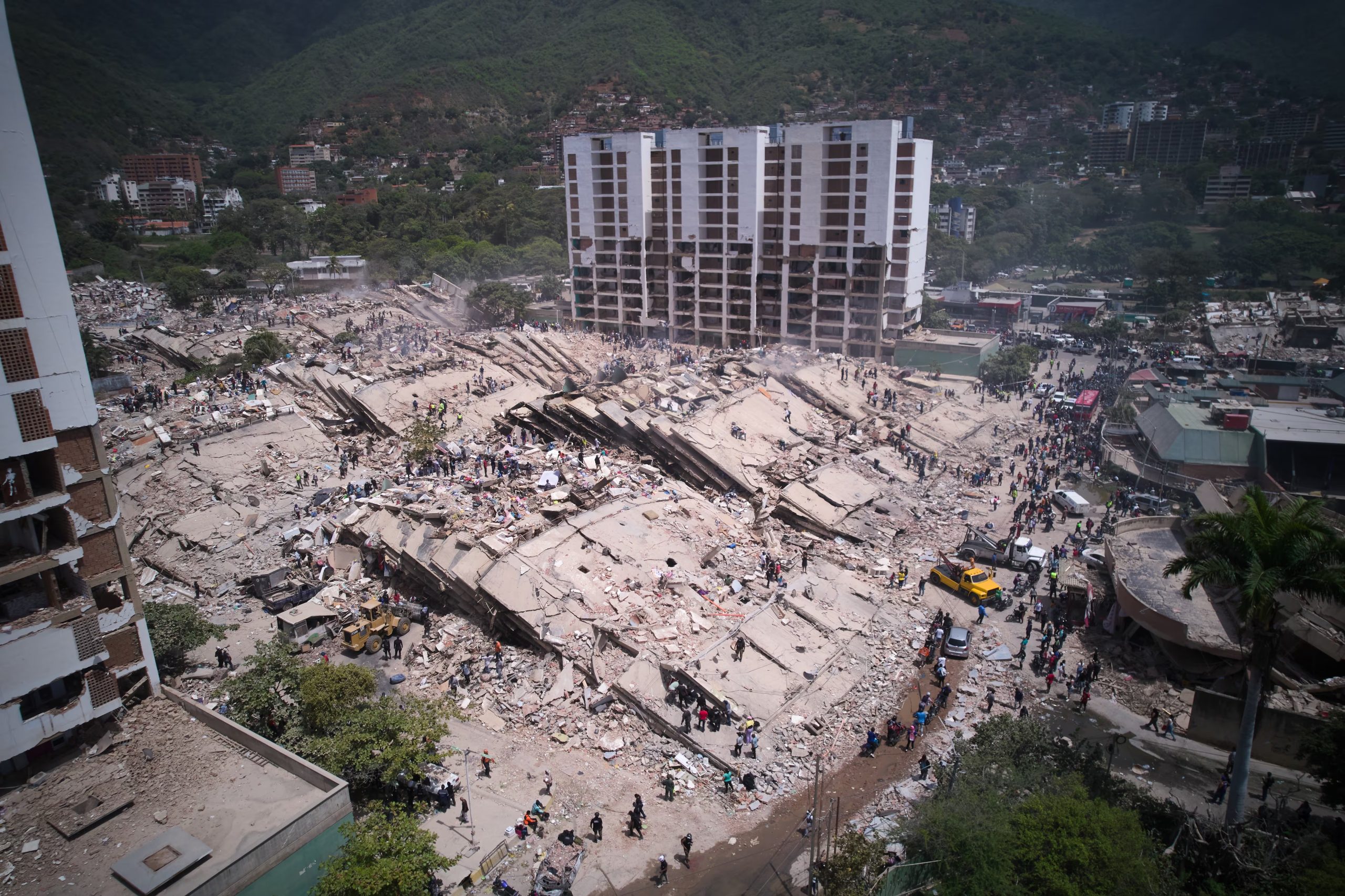 Residentes y rescatistas buscan entre los escombros dos días después de un sismo que remeció La Guaira, Venezuela, el 26 de junio de 2026. (AP Foto/Juan Pablo Arraez)