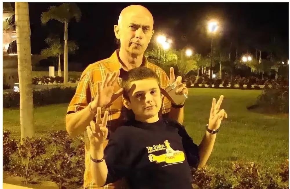 El Indio Solari y su único hijo, Bruno, posan sonrientes y haciendo el signo de la paz