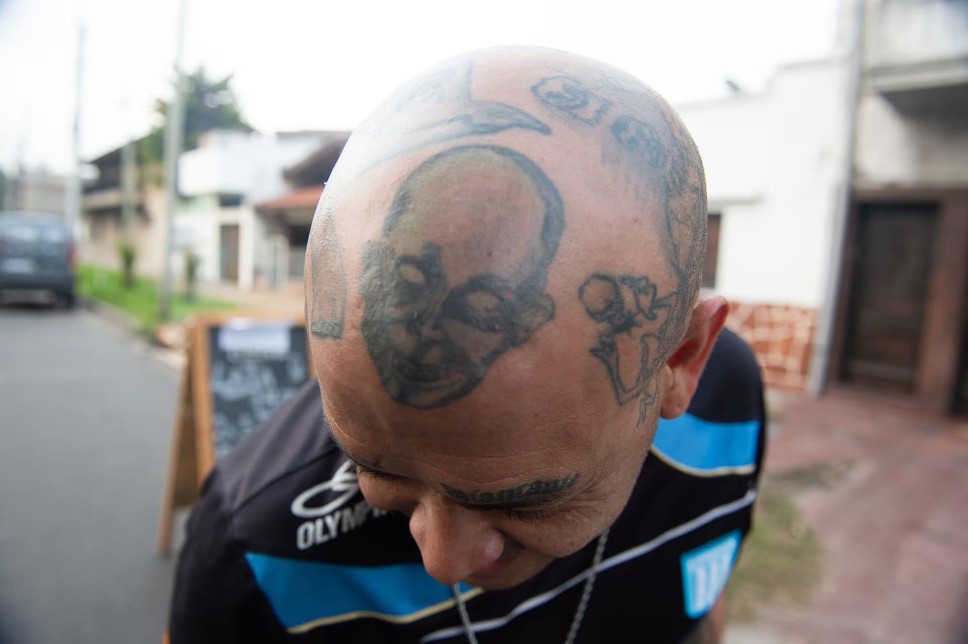 Durante el velorio, un devoto seguidor muestra los elaborados tatuajes que cubren su cabeza como parte de su homenaje al artista
