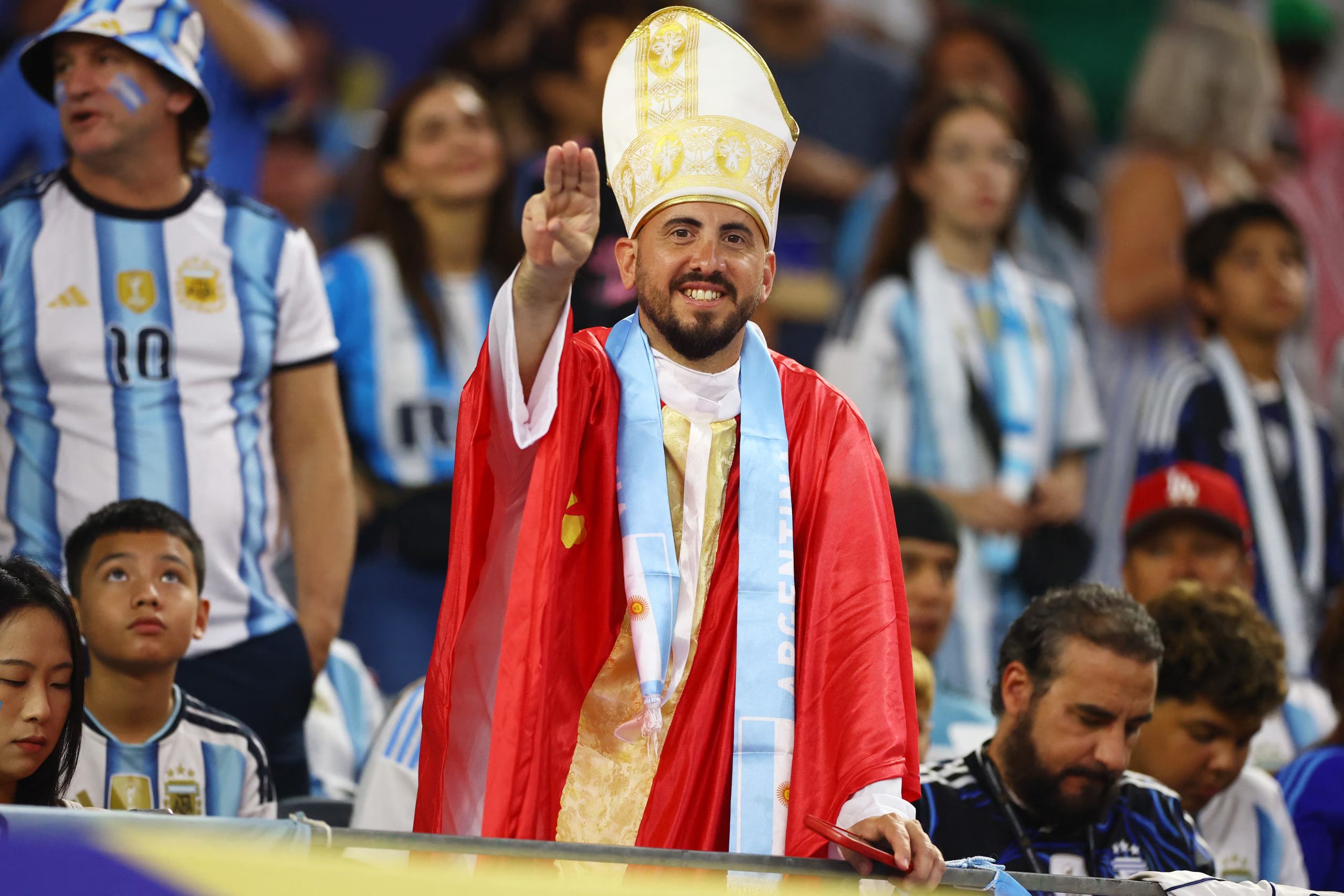 La peculiar vestimenta de un argentino: una mitra, una capa roja y una estola celeste con la bandera de Argentina