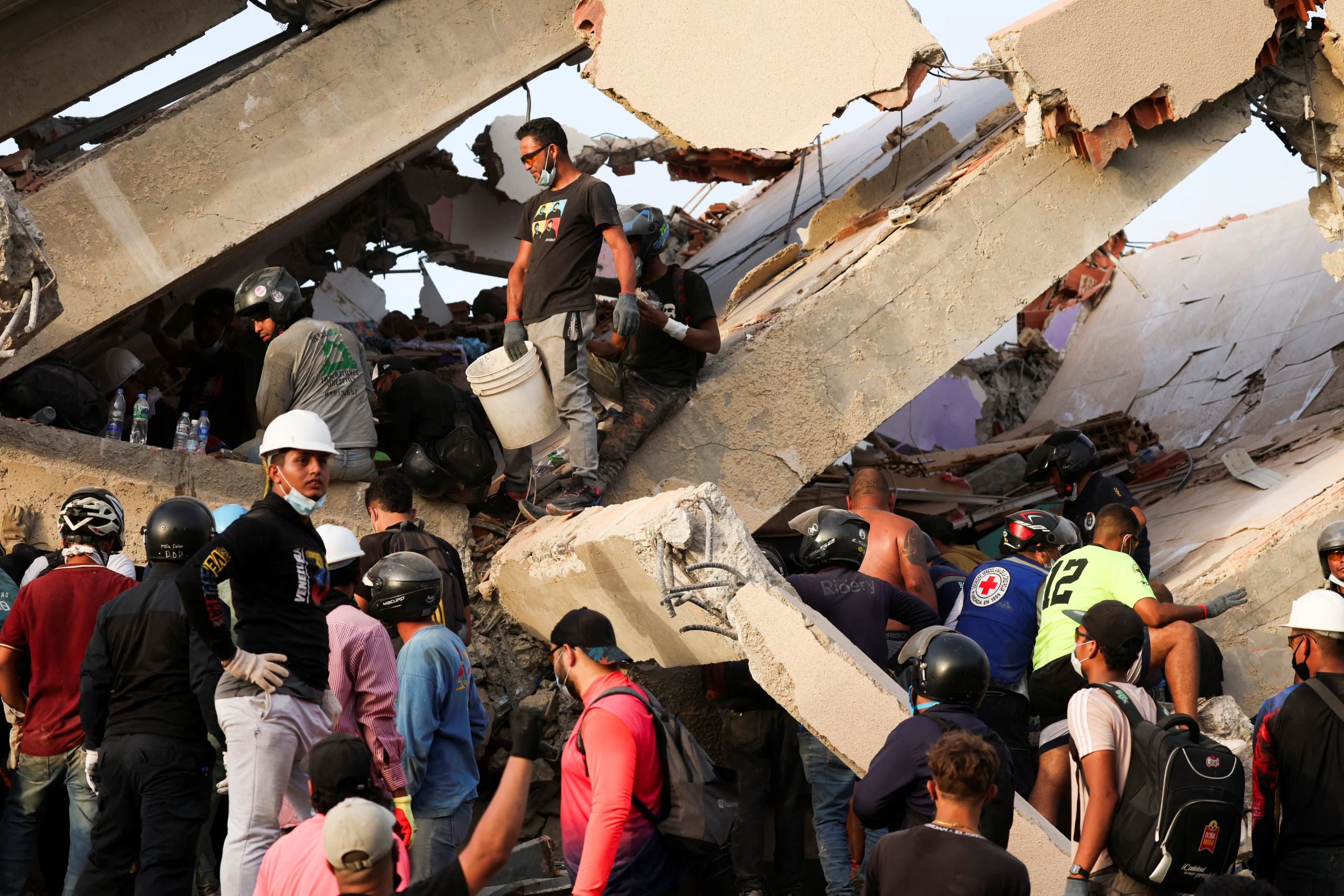 Personas buscan supervivientes entre los escombros de un edificio derrumbado tras un terremoto en La Guaira, Venezuela, el 26 de junio de 2026 (REUTERS/Leonardo Fernandez Viloria)