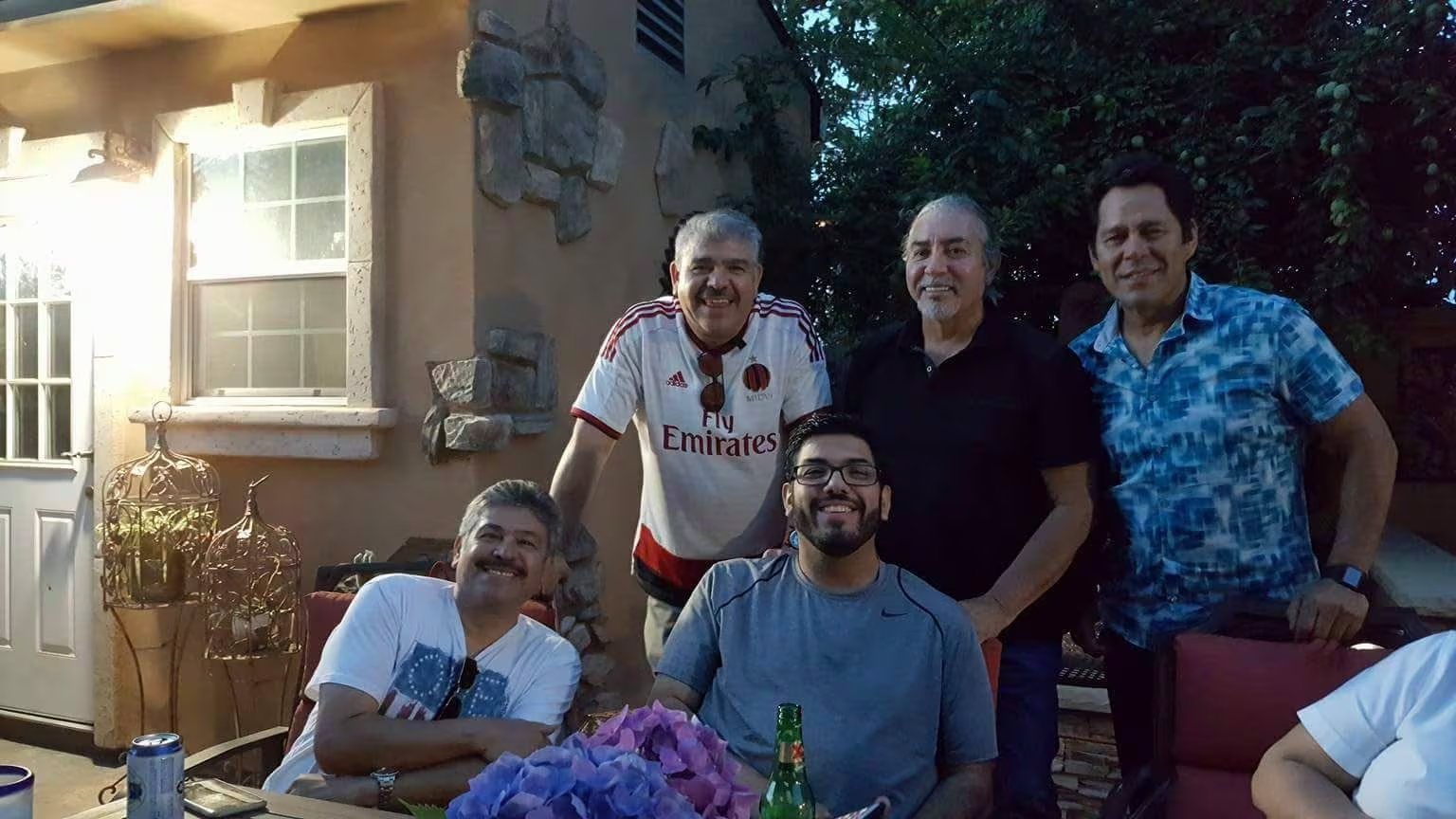 La imagen muestra a Eddie Valdivia reunido con un grupo de hombres en un ambiente exterior, posiblemente un jard&iacute;n o patio, durante una jornada social. (Facebook)
