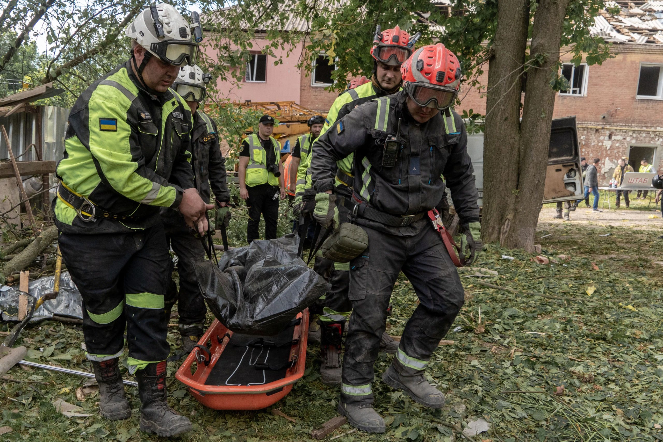 Varios rescatistas trasladan un cuerpo que retiraron de entre los escombros de un edificio de apartamentos tras un ataque ruso con misiles en Járkiv, Ucrania, el sábado 20 de junio de 2026. (AP Foto/Andrii Marienko)