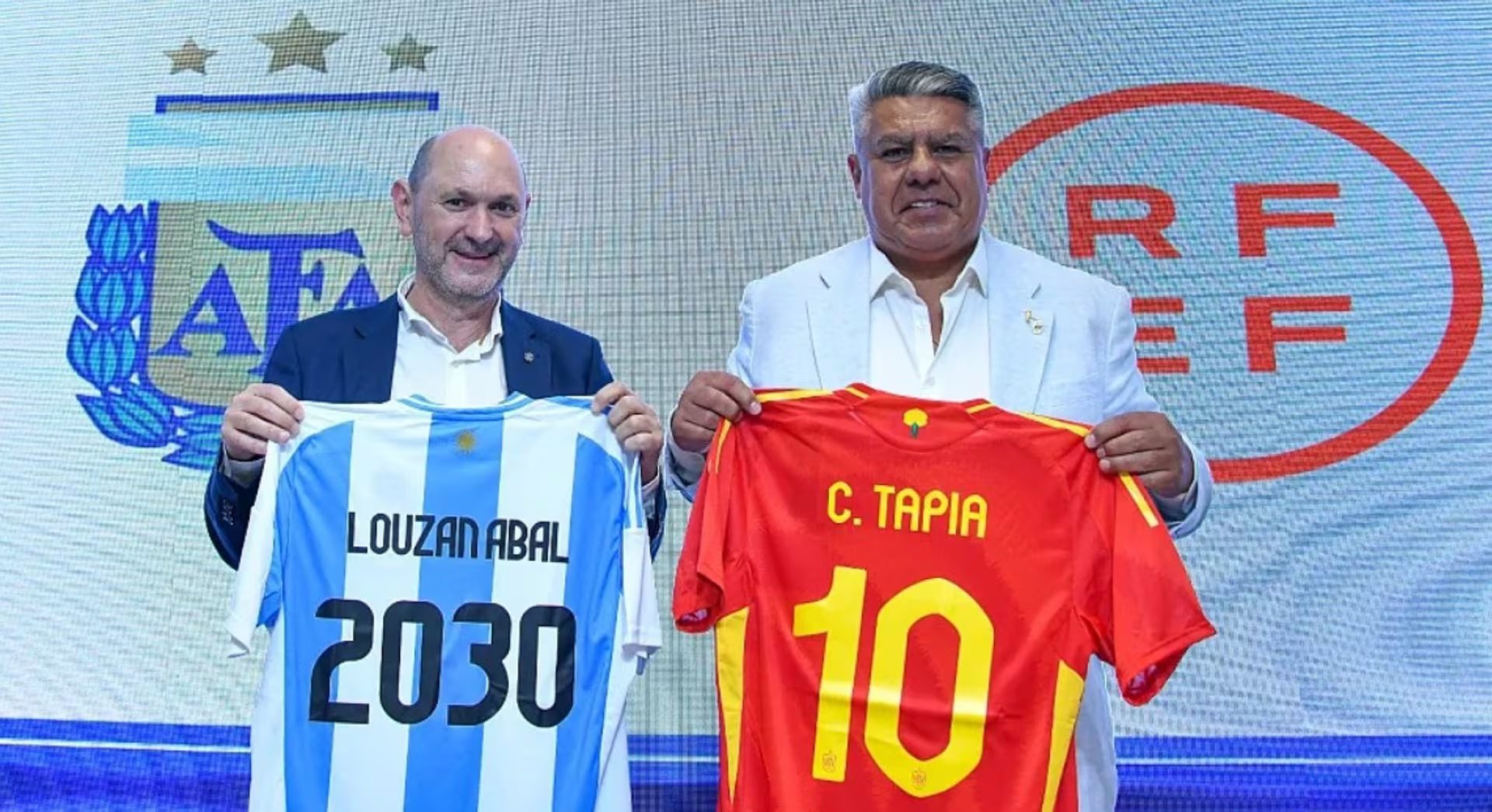 Los presidentes de las dos federaciones, con una camiseta de cada equipo. (Europa Press)