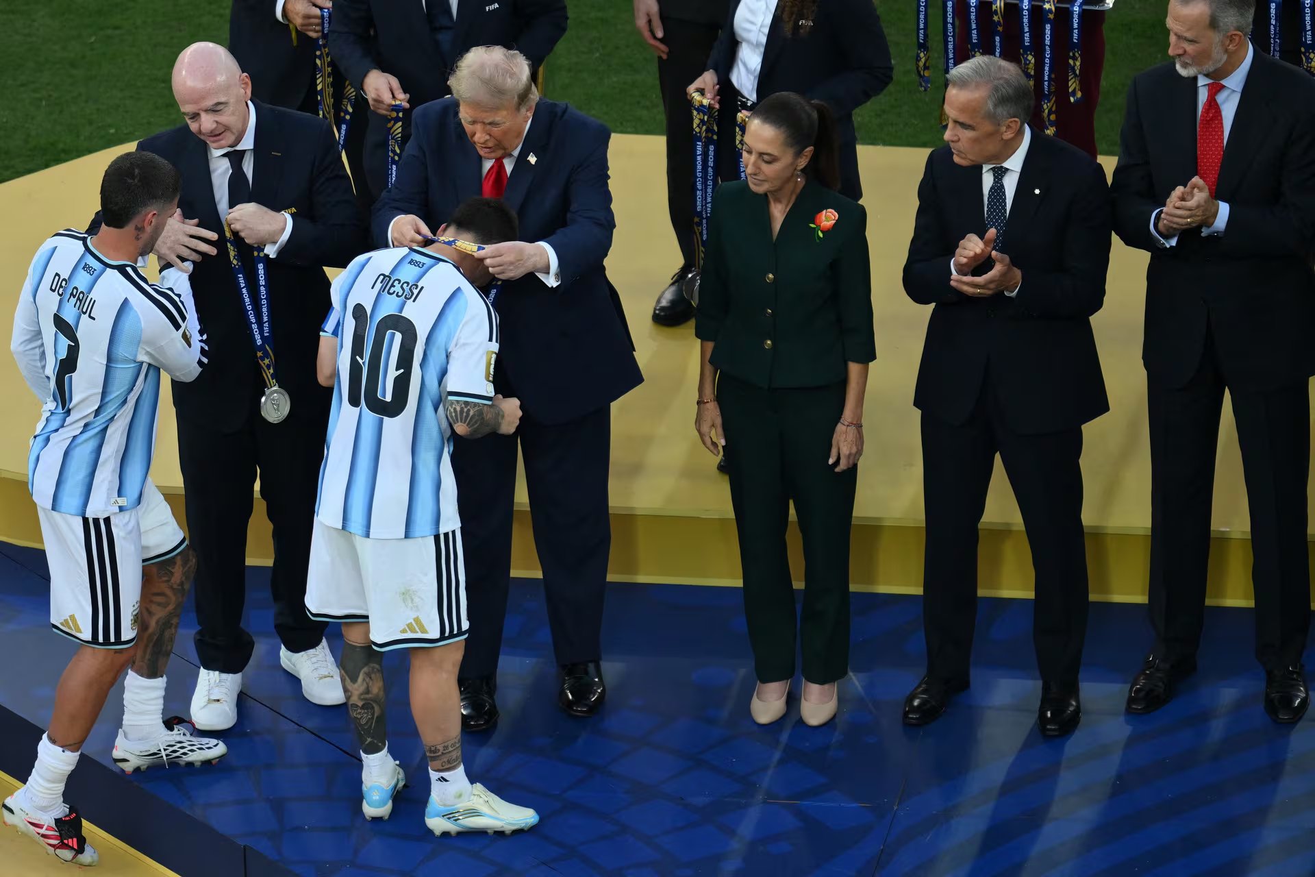 El centrocampista argentino Rodrigo De Paul (izq.) y el delantero argentino Lionel Messi (n.&deg; 10) reciben las medallas de plata de manos del presidente de la FIFA, Gianni Infantino, y del presidente de Estados Unidos, Donald Trump (der.), durante la ceremonia de clausura tras la final del Mundial de F&uacute;tbol de 2026 