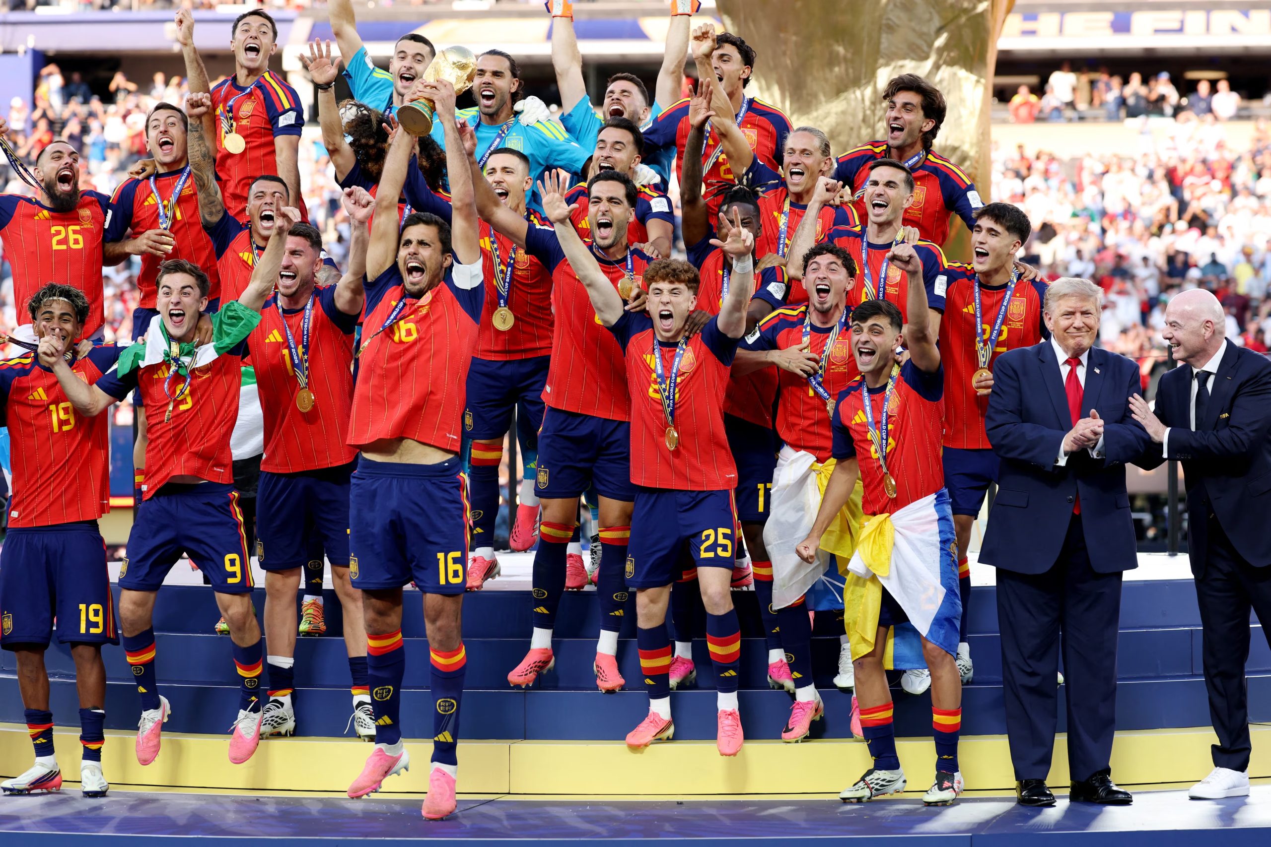 Rodri levanta el trofeo de Campe&oacute;n Mundial de la FIFA junto al presidente de Estados Unidos, Donald Trump, y el presidente de la FIFA, Gianni Infantino, tras la victoria de su equipo en la final de la Copa Mundial de la FIFA 2026 