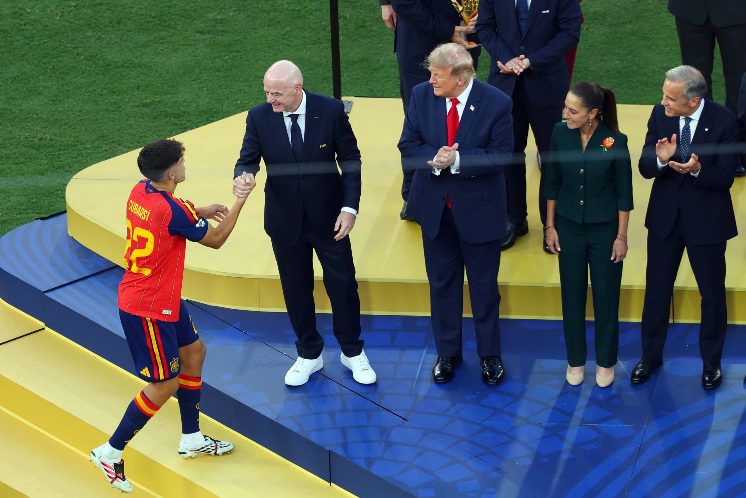 Pau Cubarsi, de Espa&ntilde;a, estrecha la mano del presidente de la FIFA, Gianni Infantino, en el podio tras ganar el premio al Mejor Jugador Joven despu&eacute;s de ganar la Copa del Mundo, mientras el presidente de Estados Unidos, Donald Trump, observa