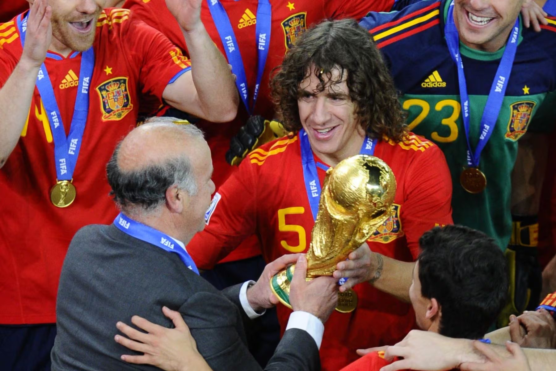 Carles Puyol recibiendo la Copa del Mundo 2010 de la mano del entrenador Vicente del Bosque (Crédito: AFP)