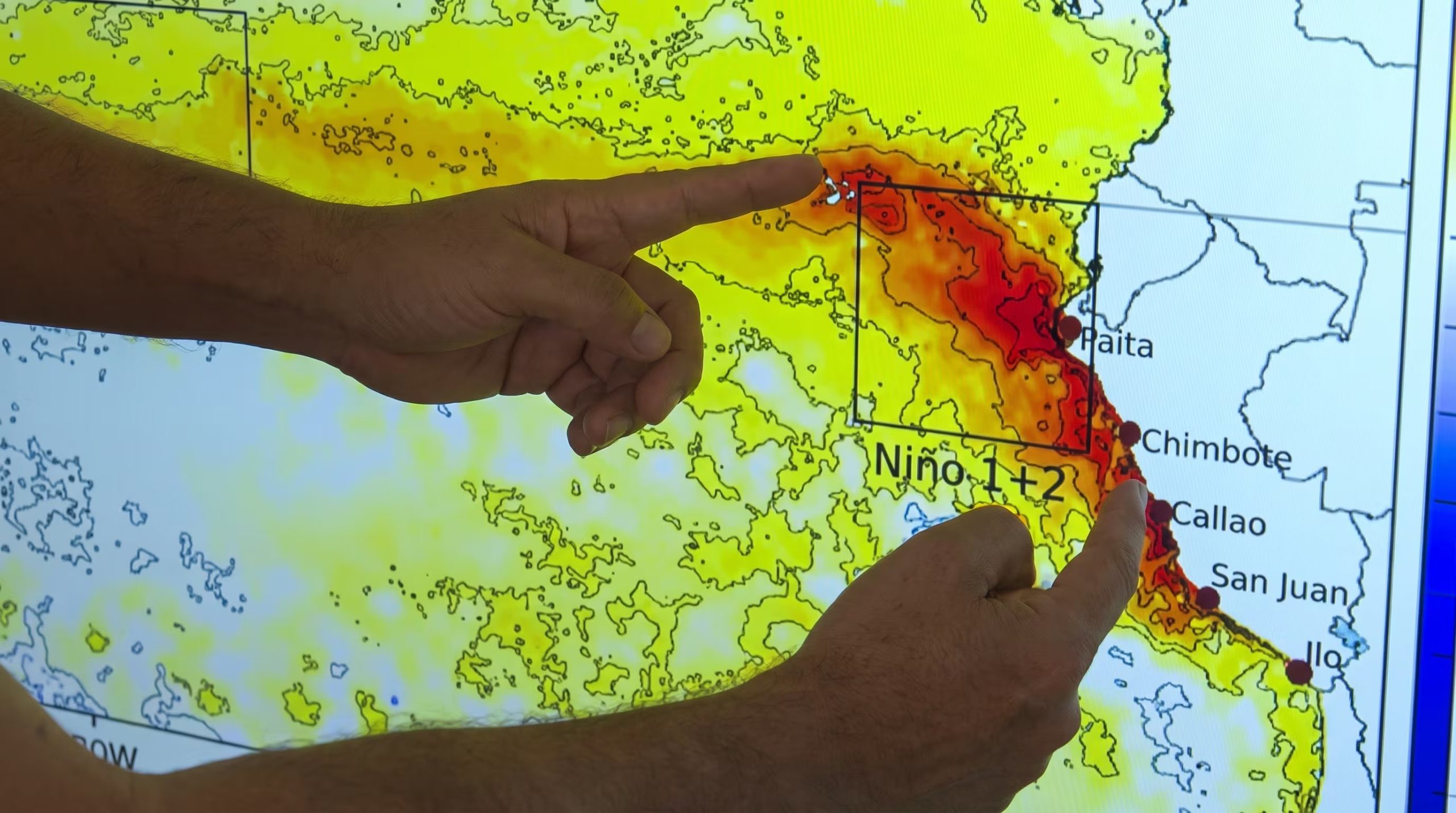 Dos manos se&ntilde;alan un mapa que indica las anomal&iacute;as de temperatura de la superficie del mar frente a la costa de Per&uacute;, asociadas al fen&oacute;meno El Ni&ntilde;o. (Senamhi)