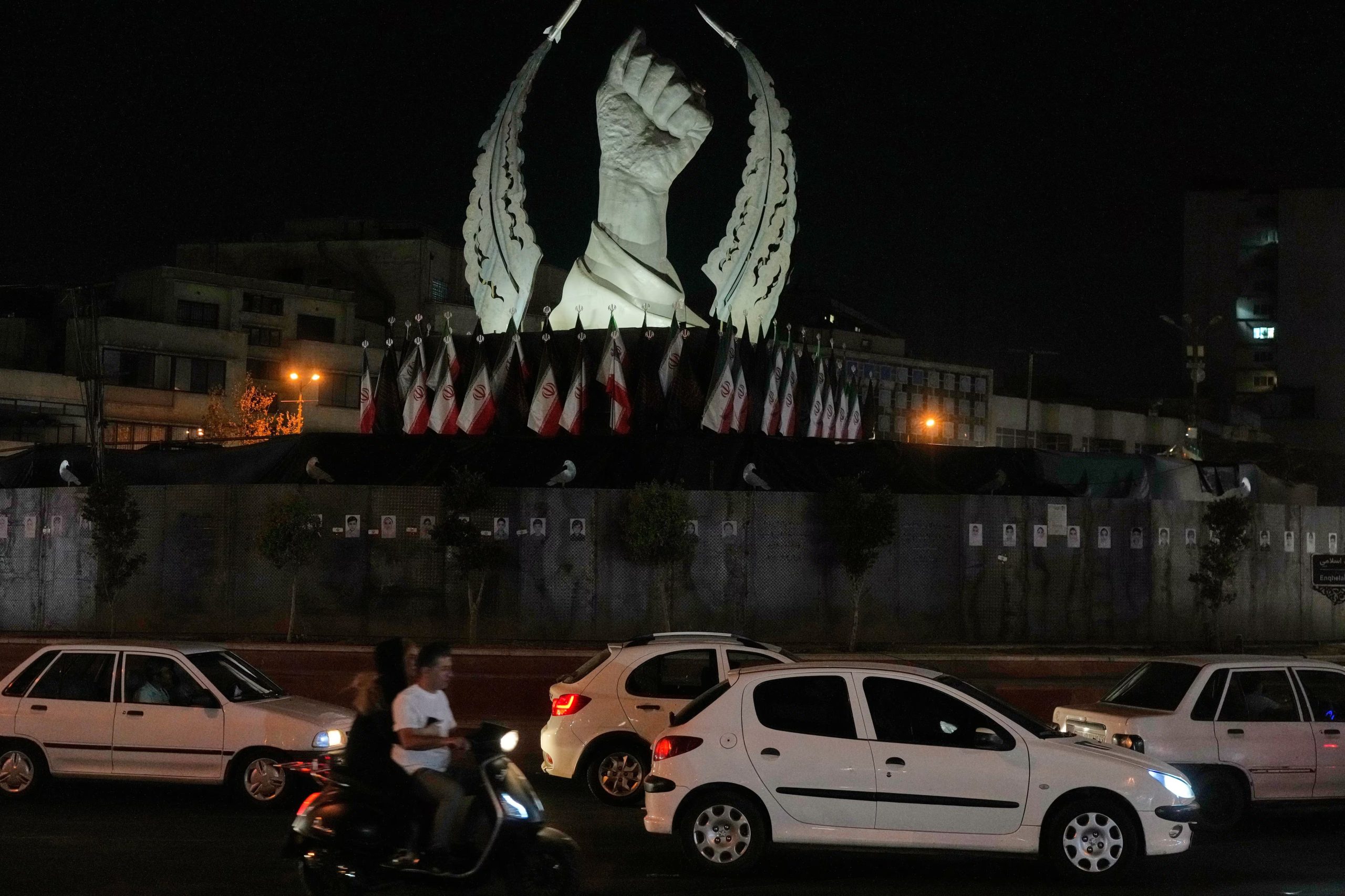 Varios veh&iacute;culos pasan ante un monumento que muestra el pu&ntilde;o cerrado del ex l&iacute;der supremo iran&iacute; Ali Khamenei, asesinado en ataques de Estados Unidos e Israel el 28 de febrero, en la plaza de la Revoluci&oacute;n Isl&aacute;mica en Teher&aacute;n, Ir&aacute;n, el domingo 19 de julio de 2026 (AP Foto/Vahid Salemi)