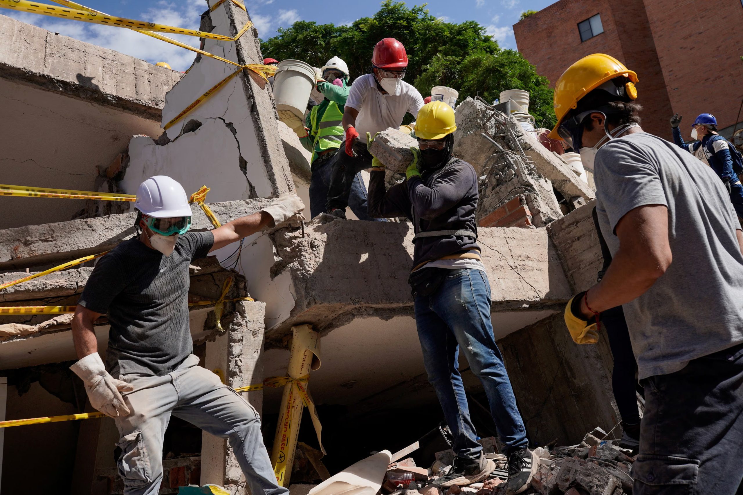 Varias personas retiran los escombros mientras se llevan a cabo las operaciones de búsqueda y rescate en el lugar donde se encontraba un edificio destruido en Cantabria, tras el terremoto ocurrido en Cali, Colombia, 13 de agosto, 2026. REUTERS/Sergio Acero